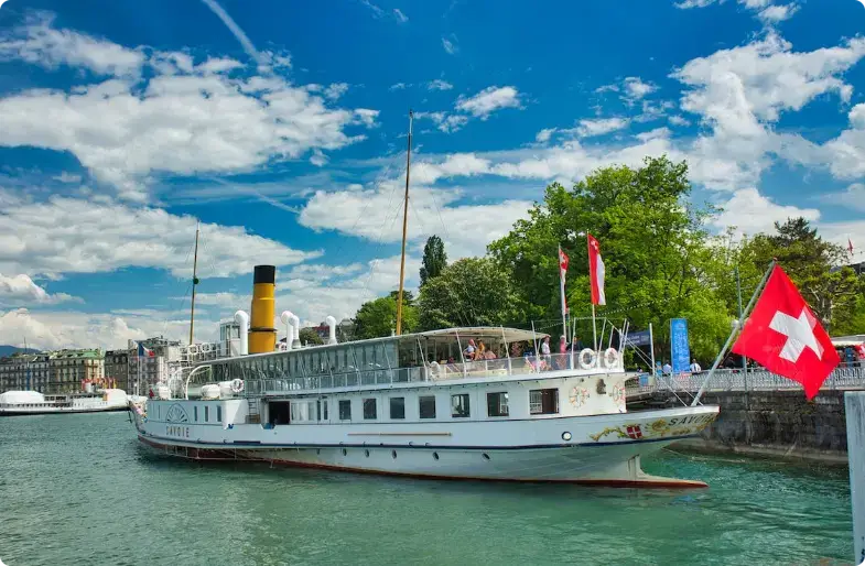 Classic white steamboat docked in Swiss harbor with Swiss flag