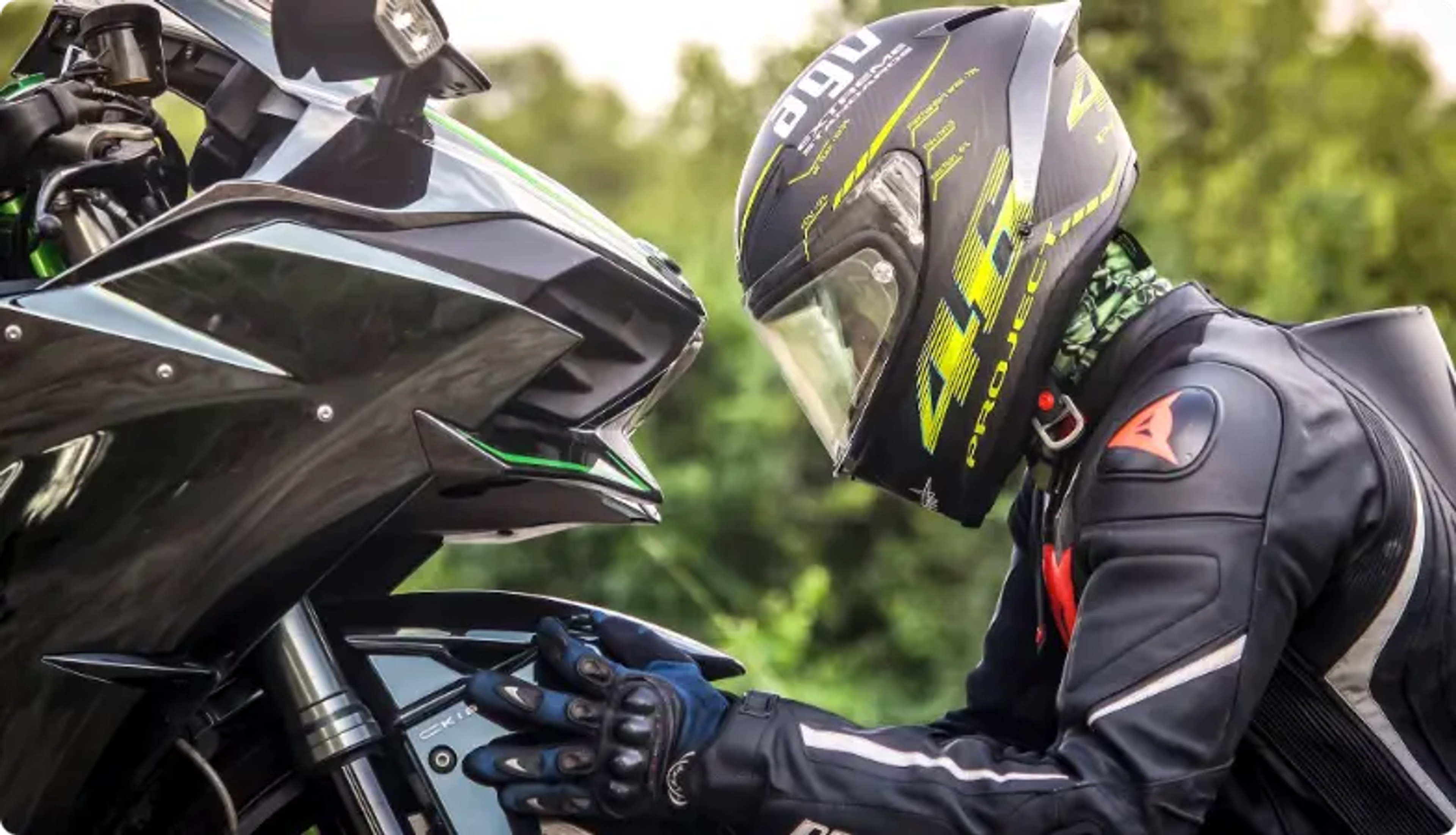 黒とネオンのヘルメットをかぶったバイカーがバイクのコントロールを調整している