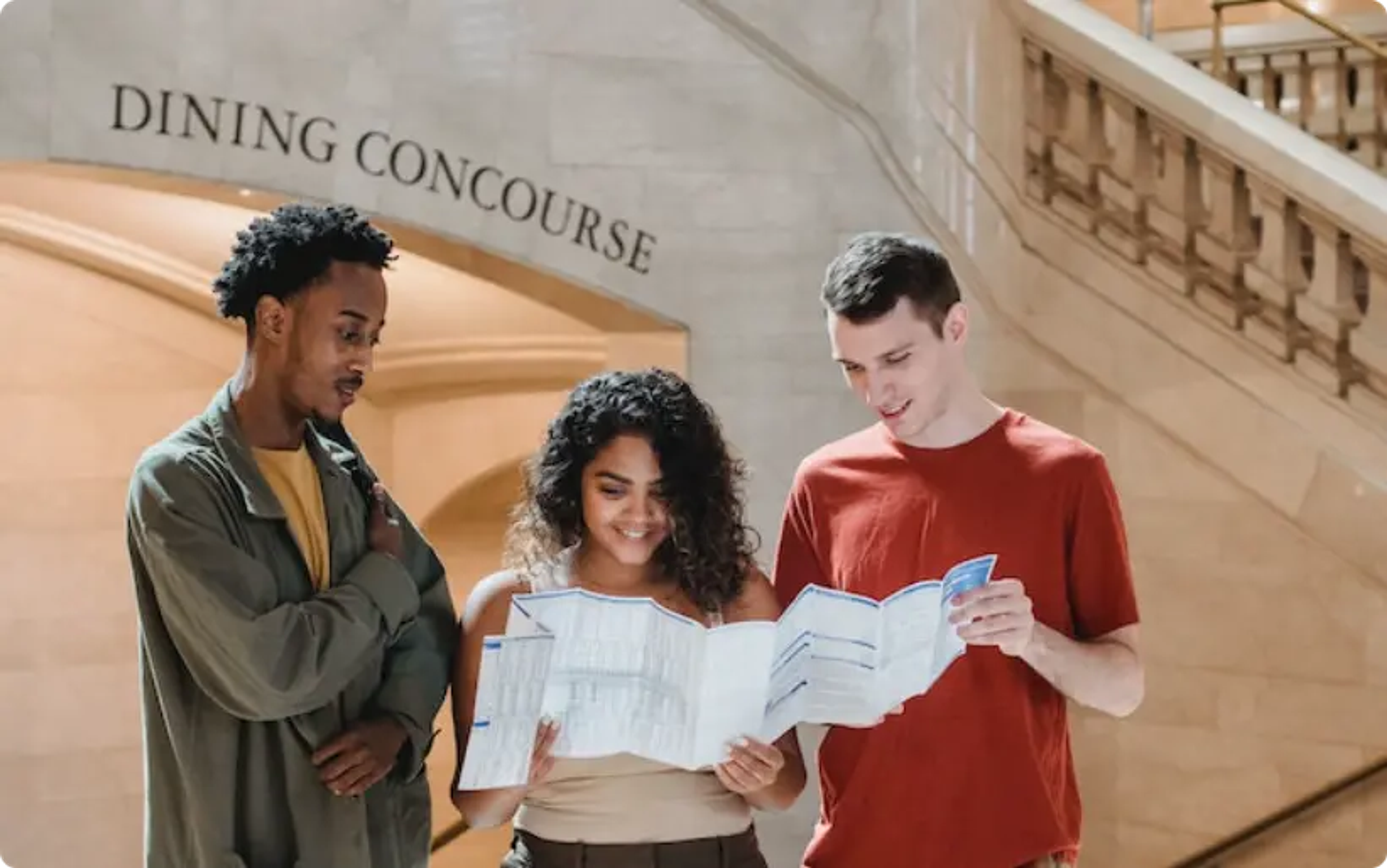 Trois étudiants examinant des documents dans le couloir de la salle à manger