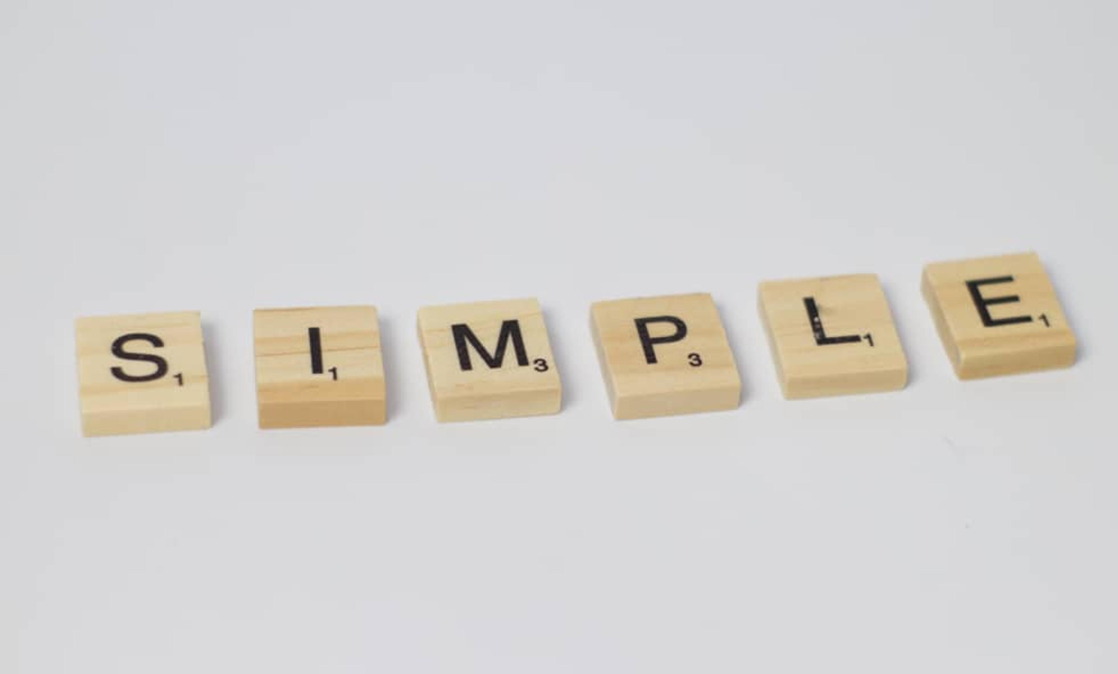 Scrabble letter tiles spelling out the word 'SIMPLE' on a white background