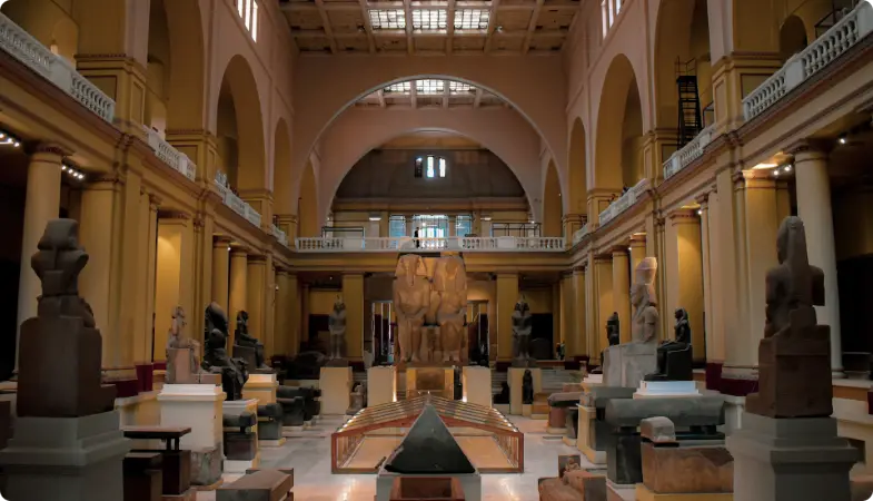 Oude Egyptische artefacten tentoongesteld in grote museumhal met architecturale zuilen