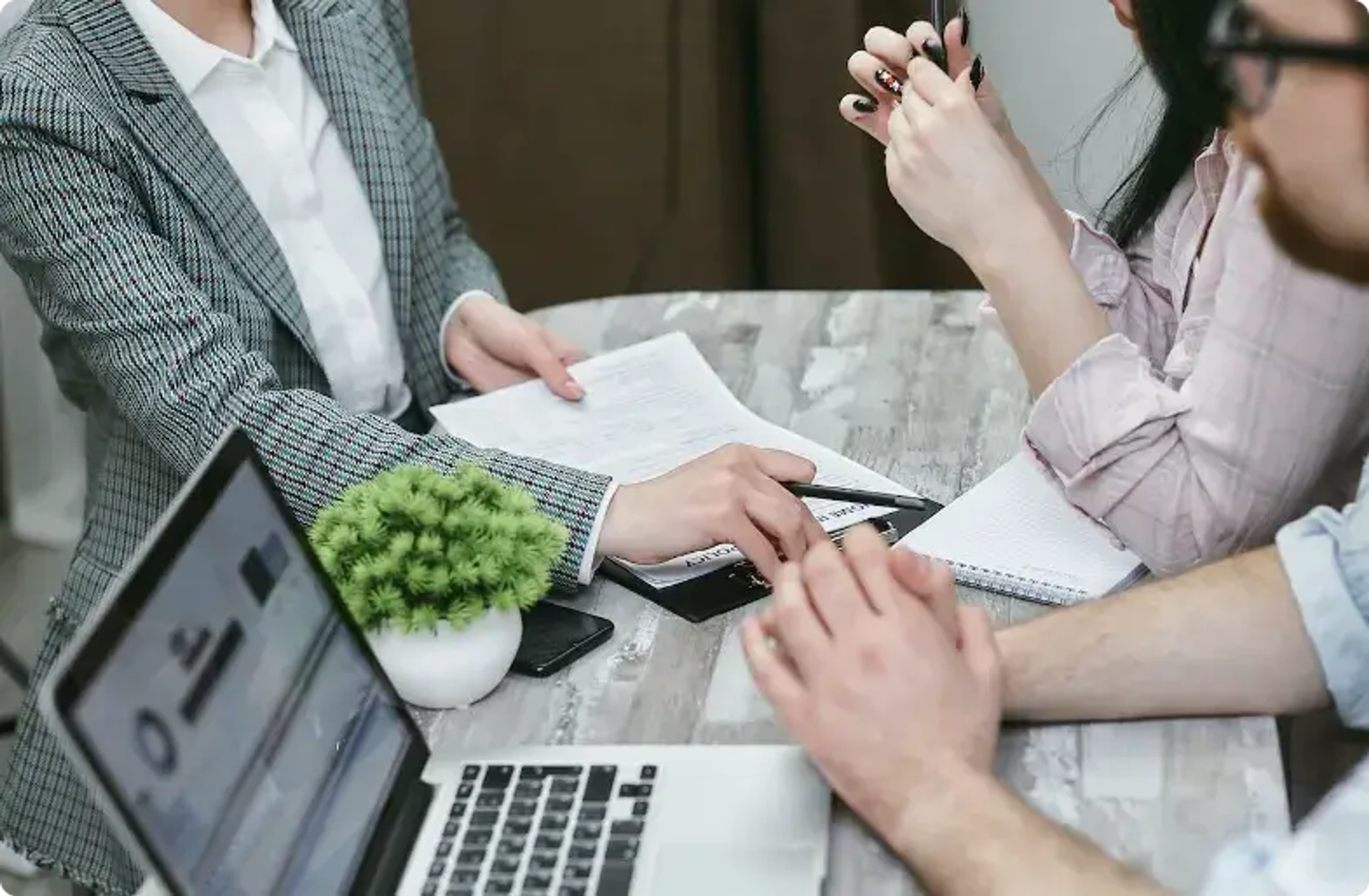 Professionele vergadering met laptop, documenten en handen tijdens een discussie