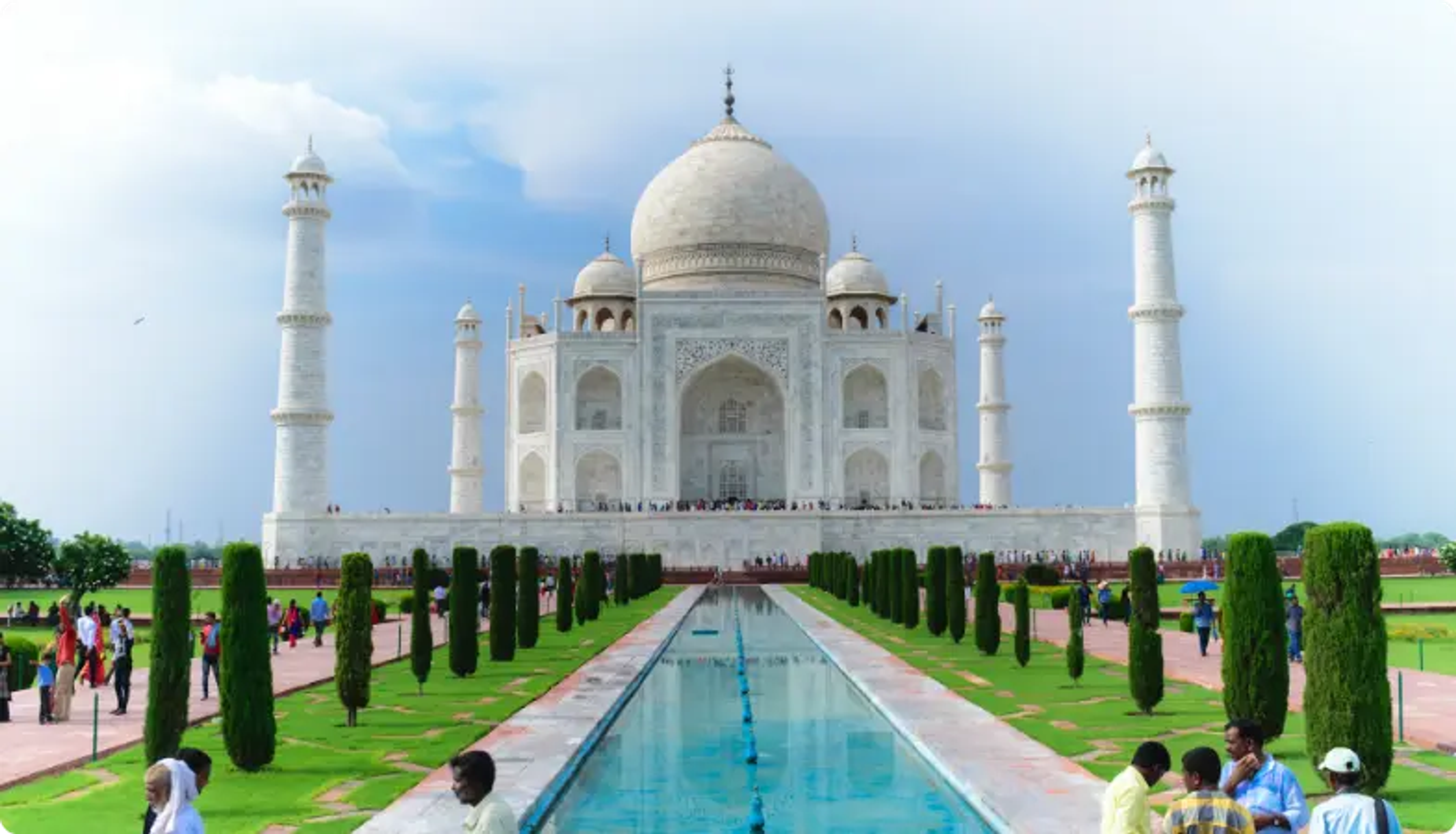 Taj Mahal with reflective pool and cypress trees on a clear day