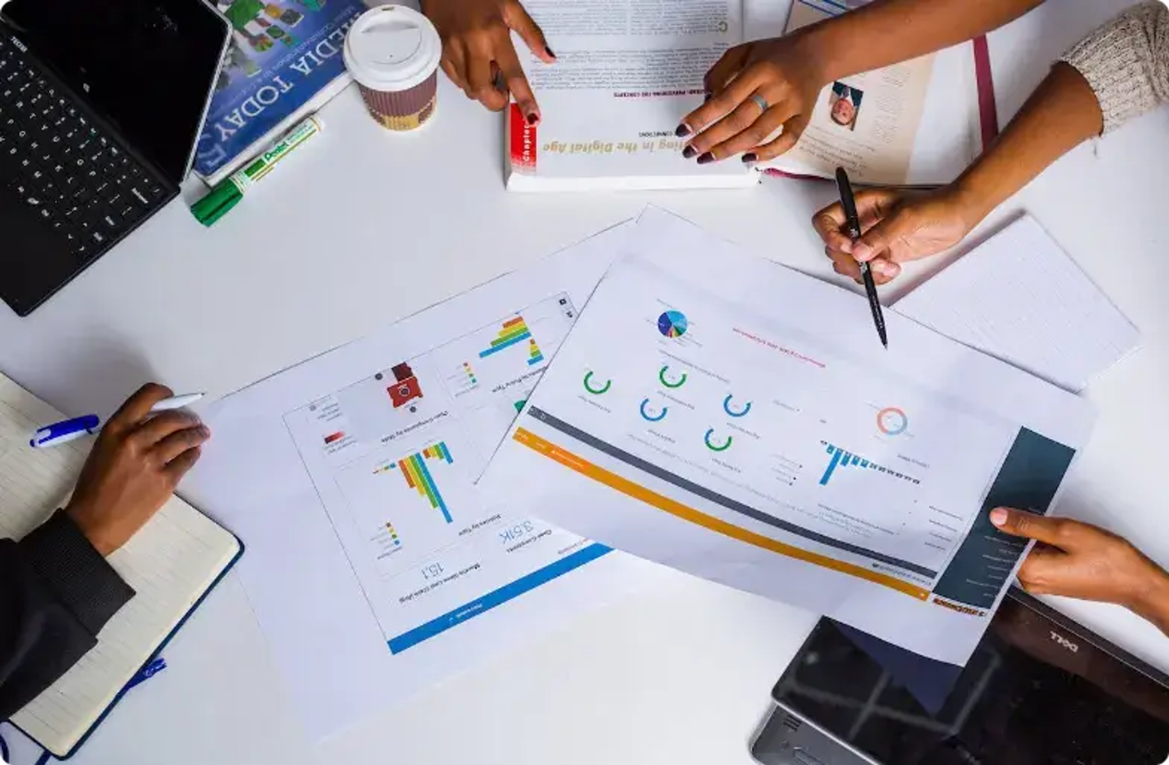 Mains analysant des graphiques et des données sur une table de travail