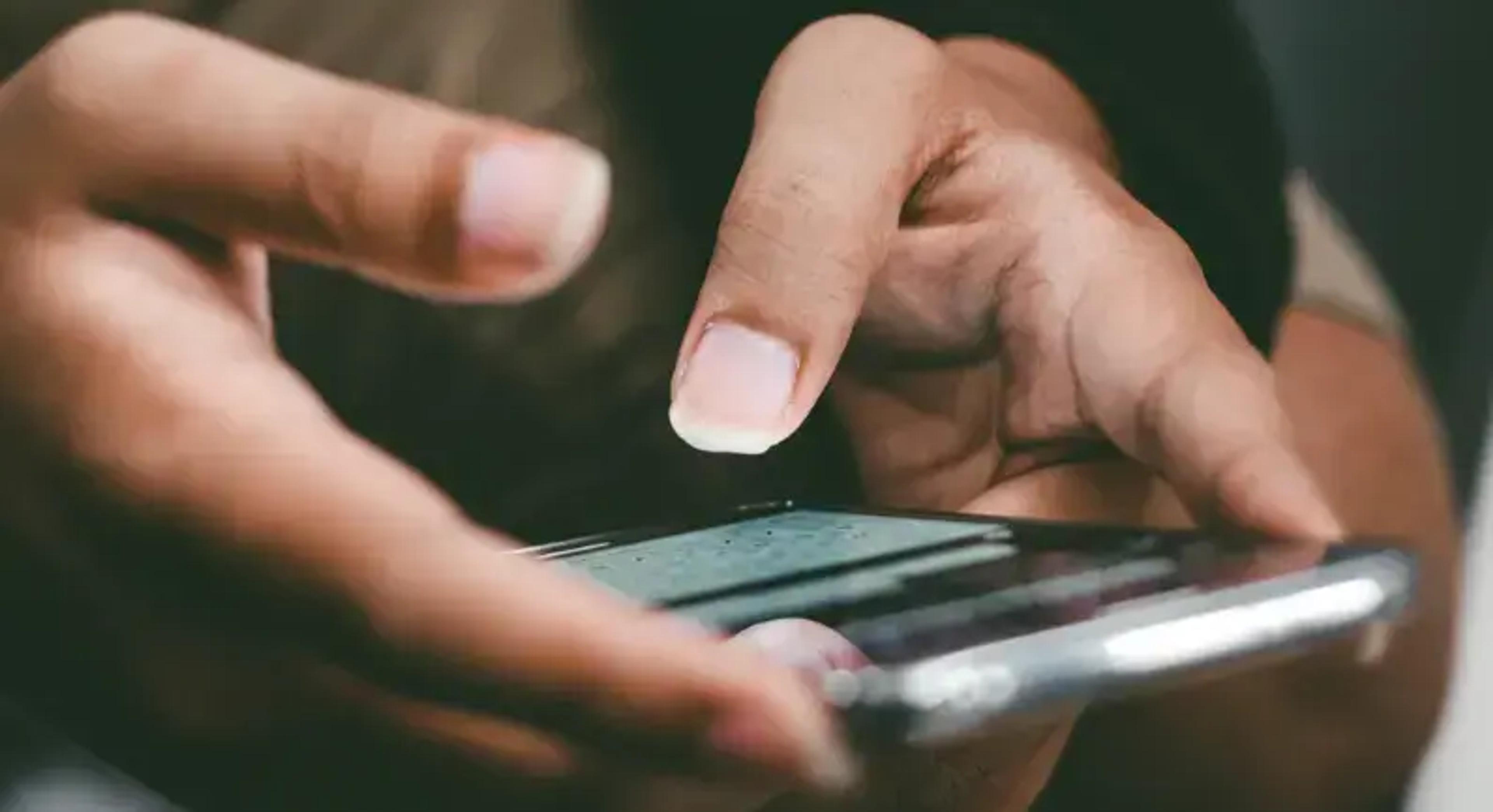 Nærbillede af hænder, der skriver på en smartphone-touchscreen