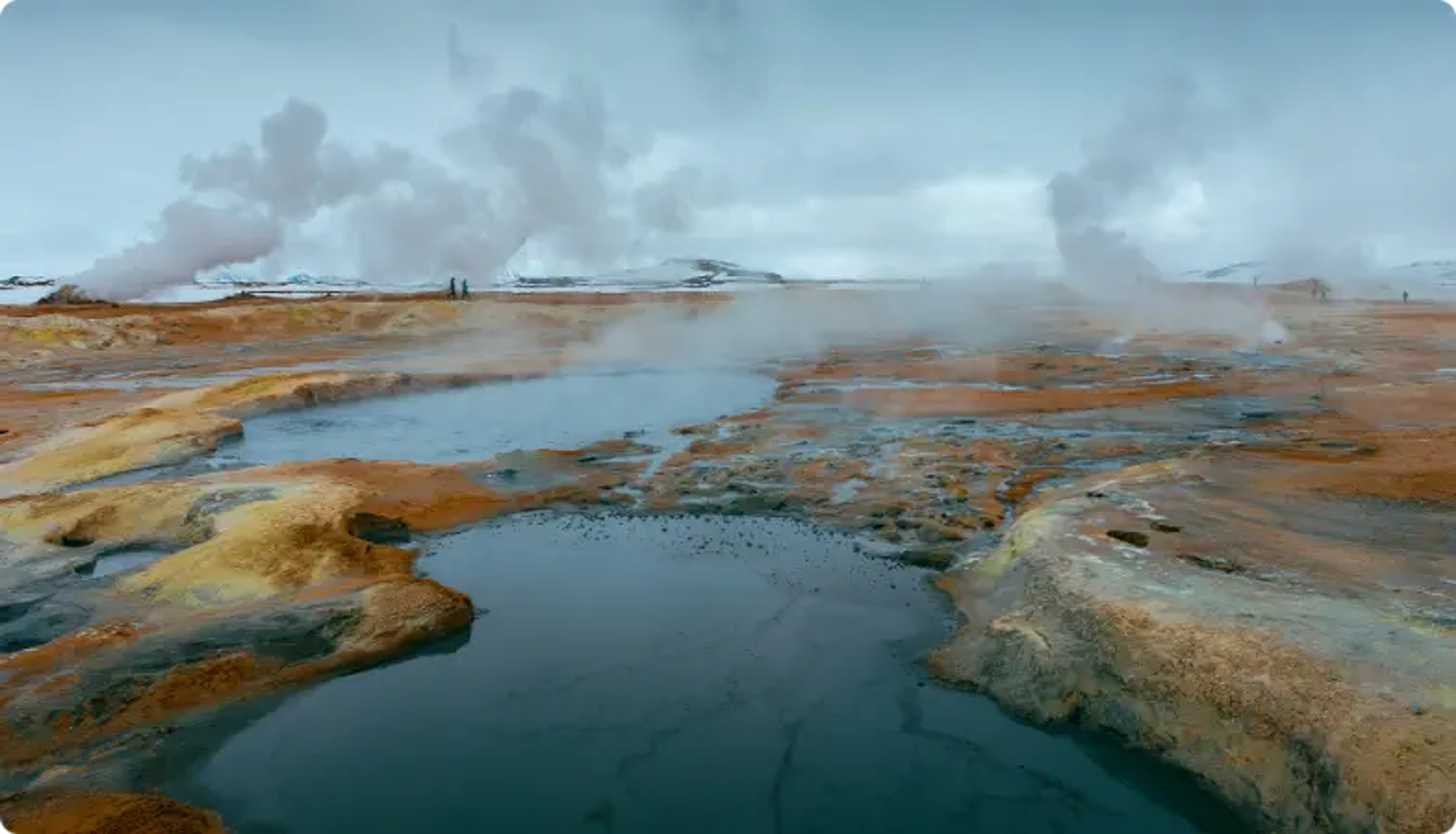 Stomende geothermische poelen met kleurrijke mineraalafzettingen in een kaal landschap