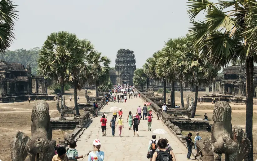 Turyści idący w kierunku wejścia do starożytnej świątyni w Angkor Wat, Kambodża