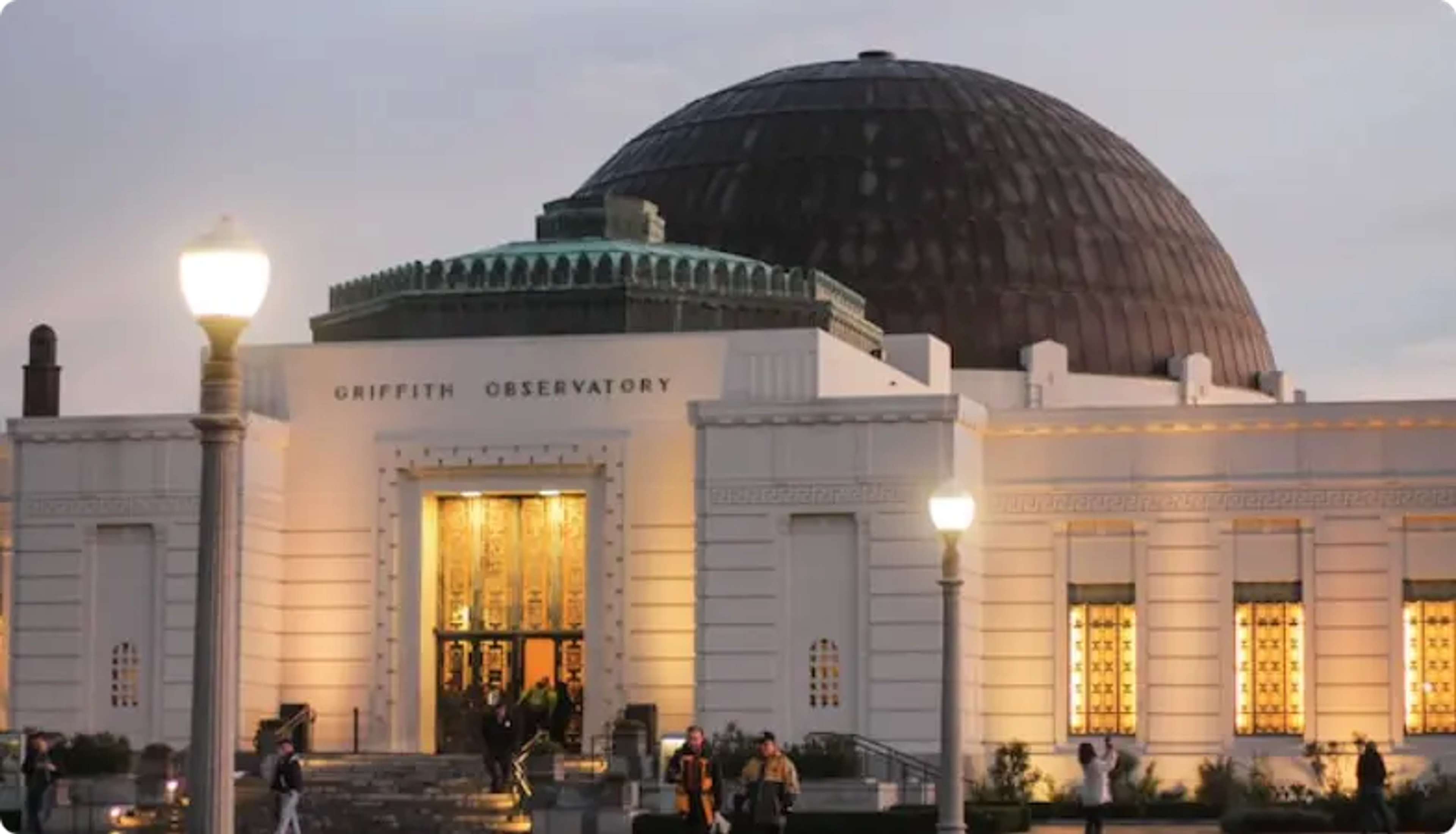 Observatorio Griffith al anochecer con cúpula iluminada y ventanas cálidas brillantes