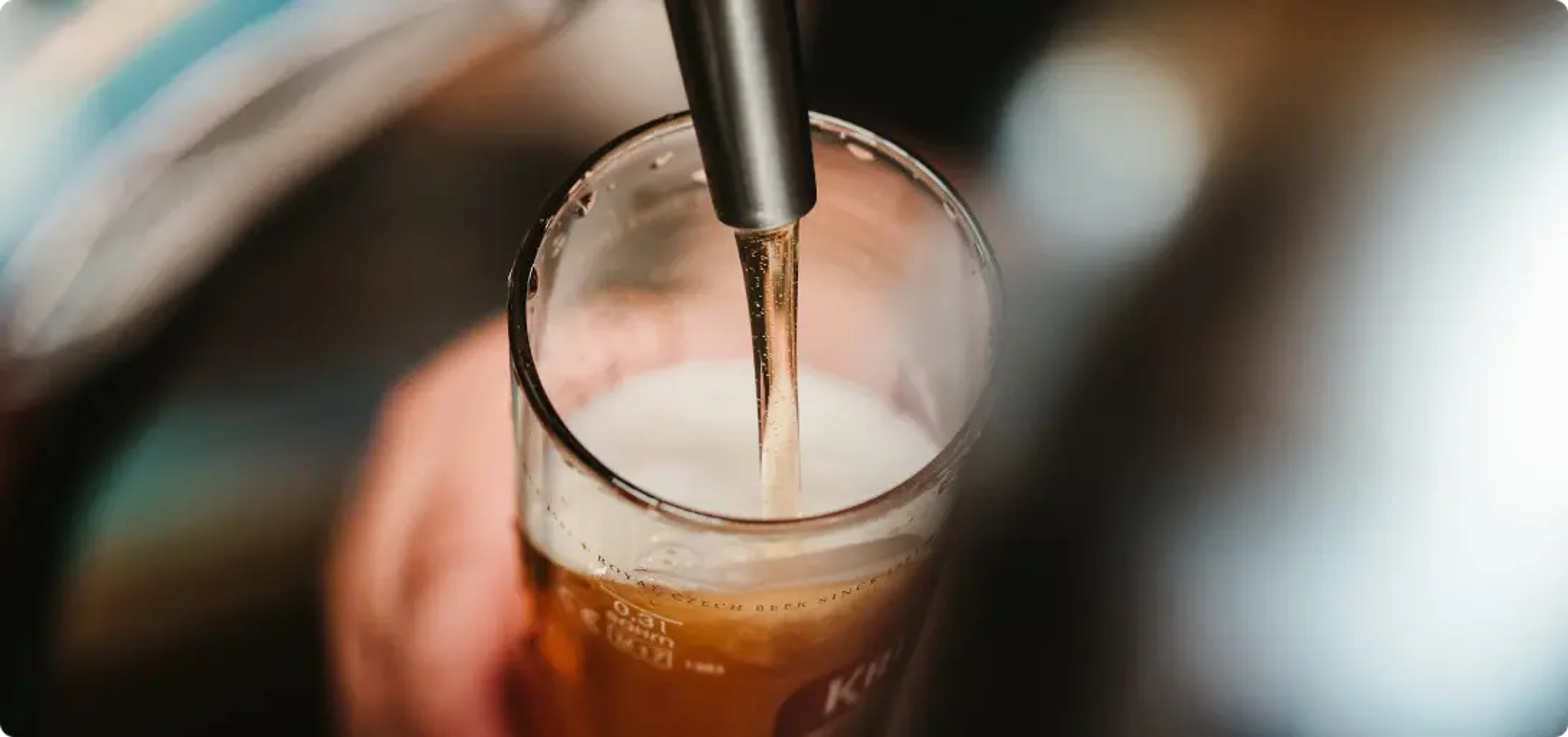 a glass of beer poured down in a distillery tour