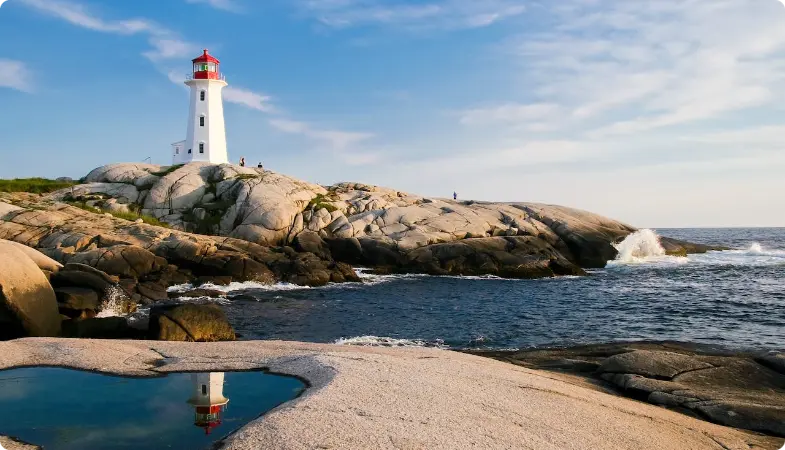 Farol branco em uma paisagem costeira rochosa com reflexão em poça de maré