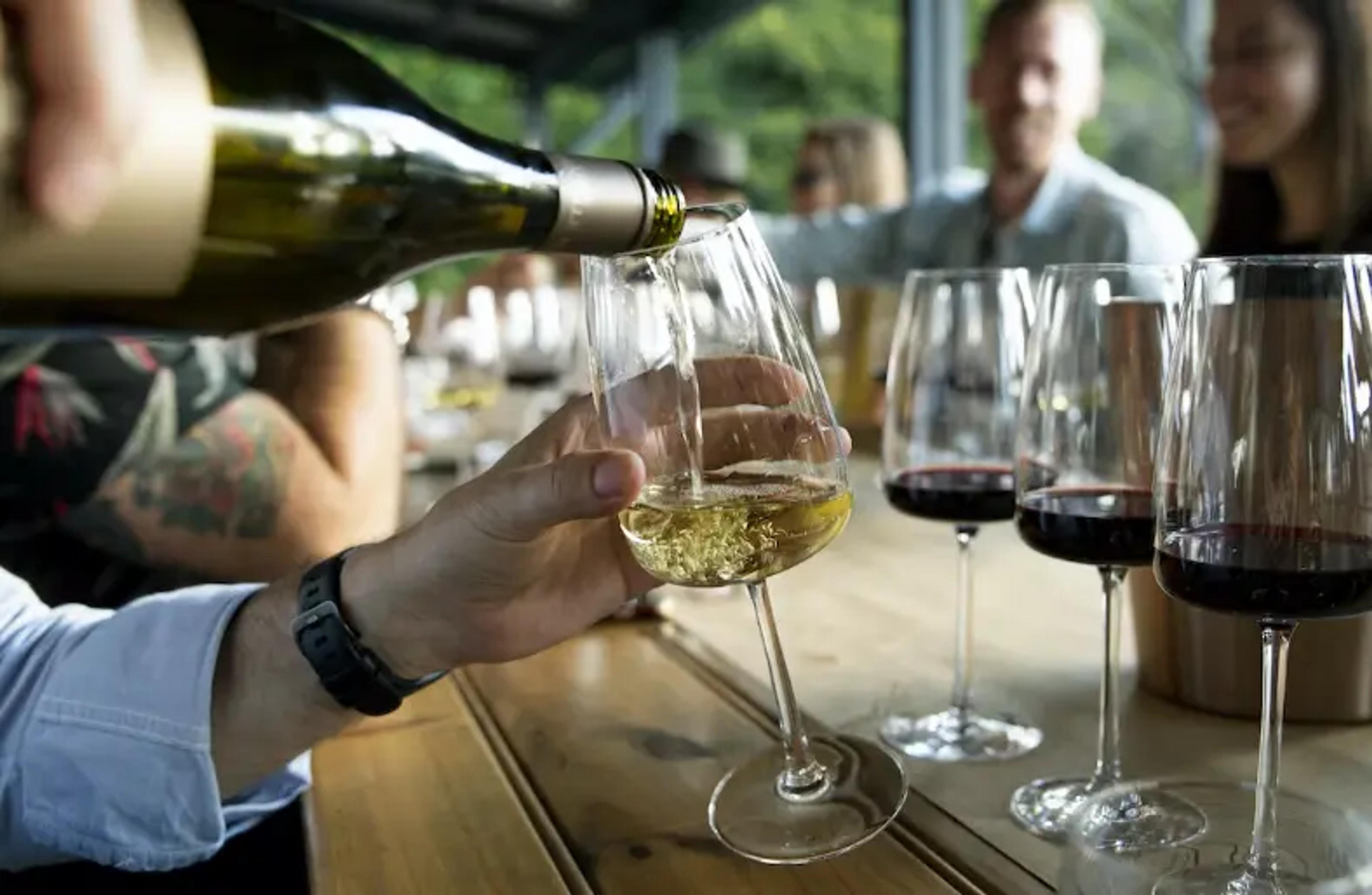 Witte wijn wordt in een glas geschonken tijdens een wijnproeverij