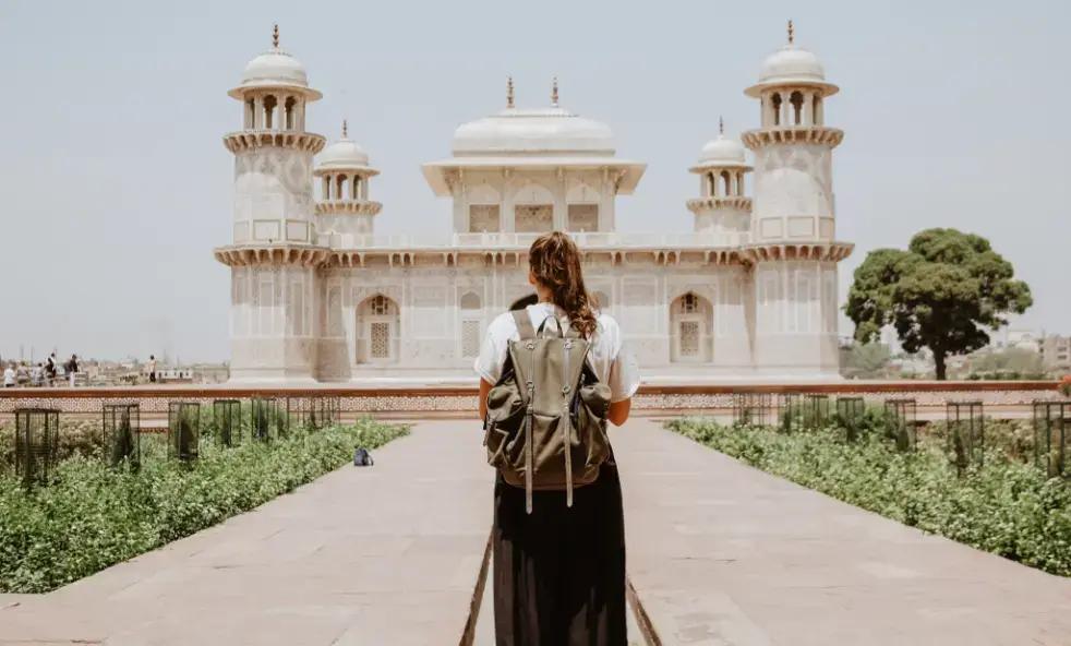 Reiziger met rugzak nadert sierlijke witte Mughal-architectuur in India
