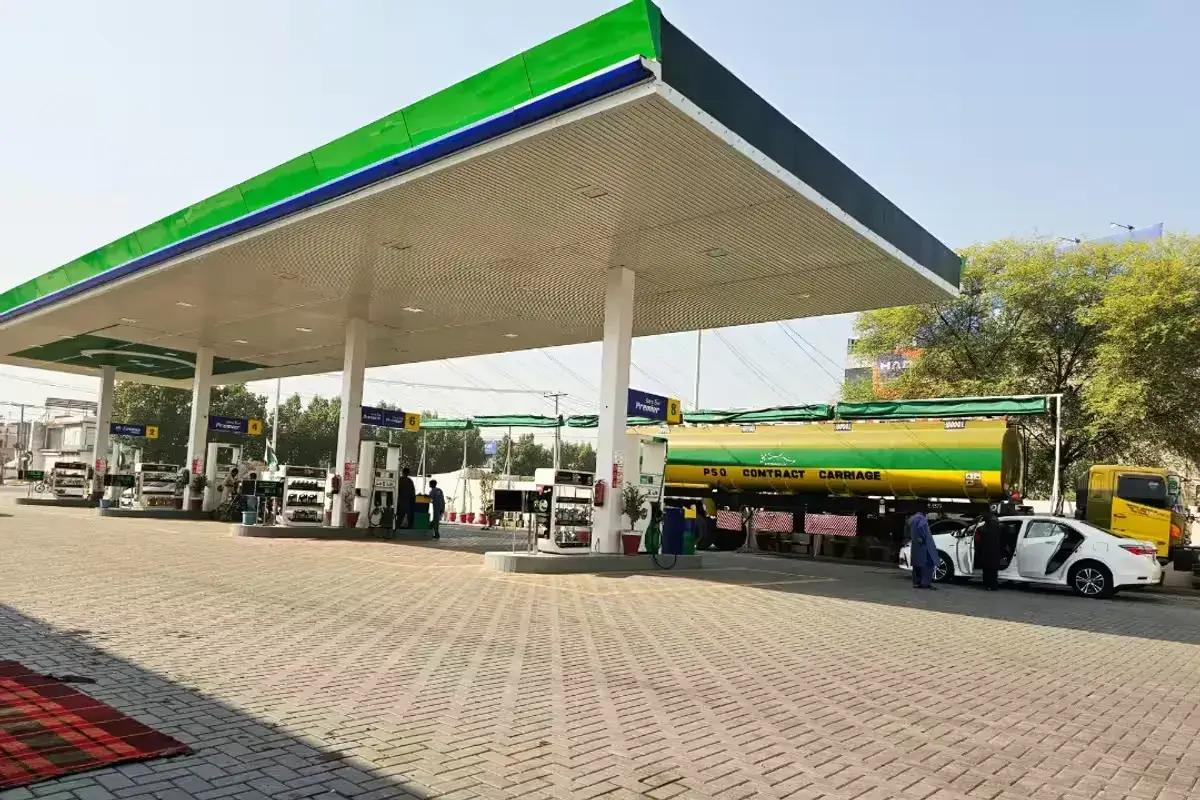Fuel station forecourt with pumps under a green canopy