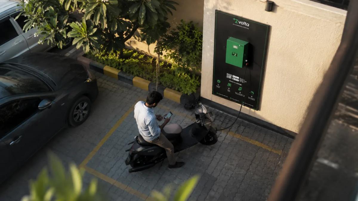 A Zvolta wall charger in a parking area, seen from above, with a scooter charging