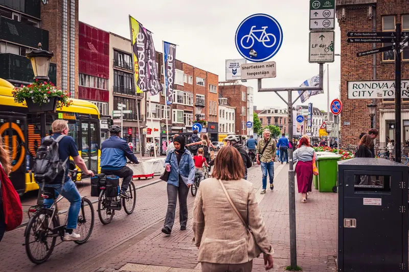 Oranje kraampjes langs de Oudegracht tijdens Koningsdag in Utrecht met feestvierders