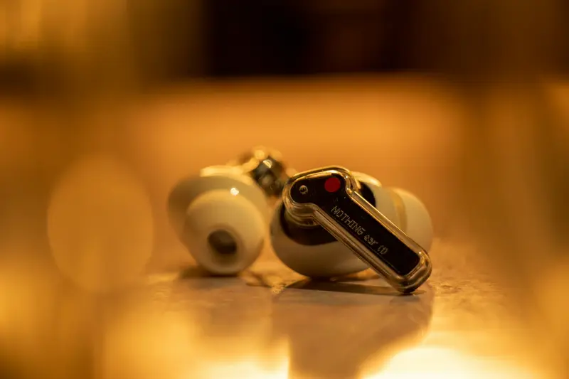 Persoon met draadloze in-ear oordopjes in en smartphone met muziek-app
