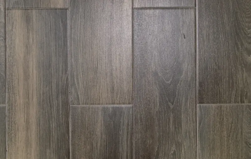 Persoon die zelf laminaat legt in een lichte moderne woonkamer