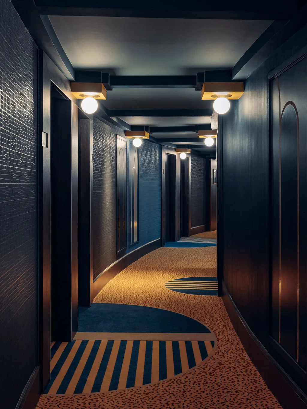 Curved corridor with globe sconces and striped carpet, Nest MGallery Hotel, Paris