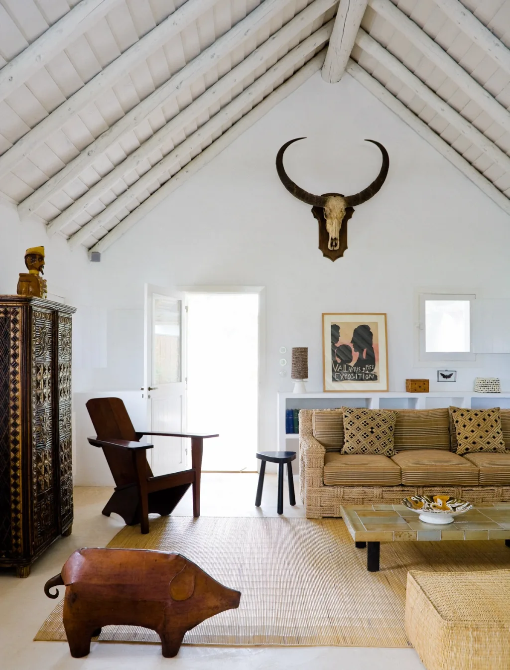 White raftered living room with woven seating and a horned skull, Jacques Grange, Comporta