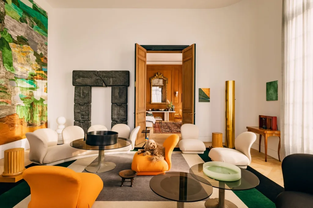 White and orange lounge seating among artworks in Laurent Buttazzoni's Paris interior
