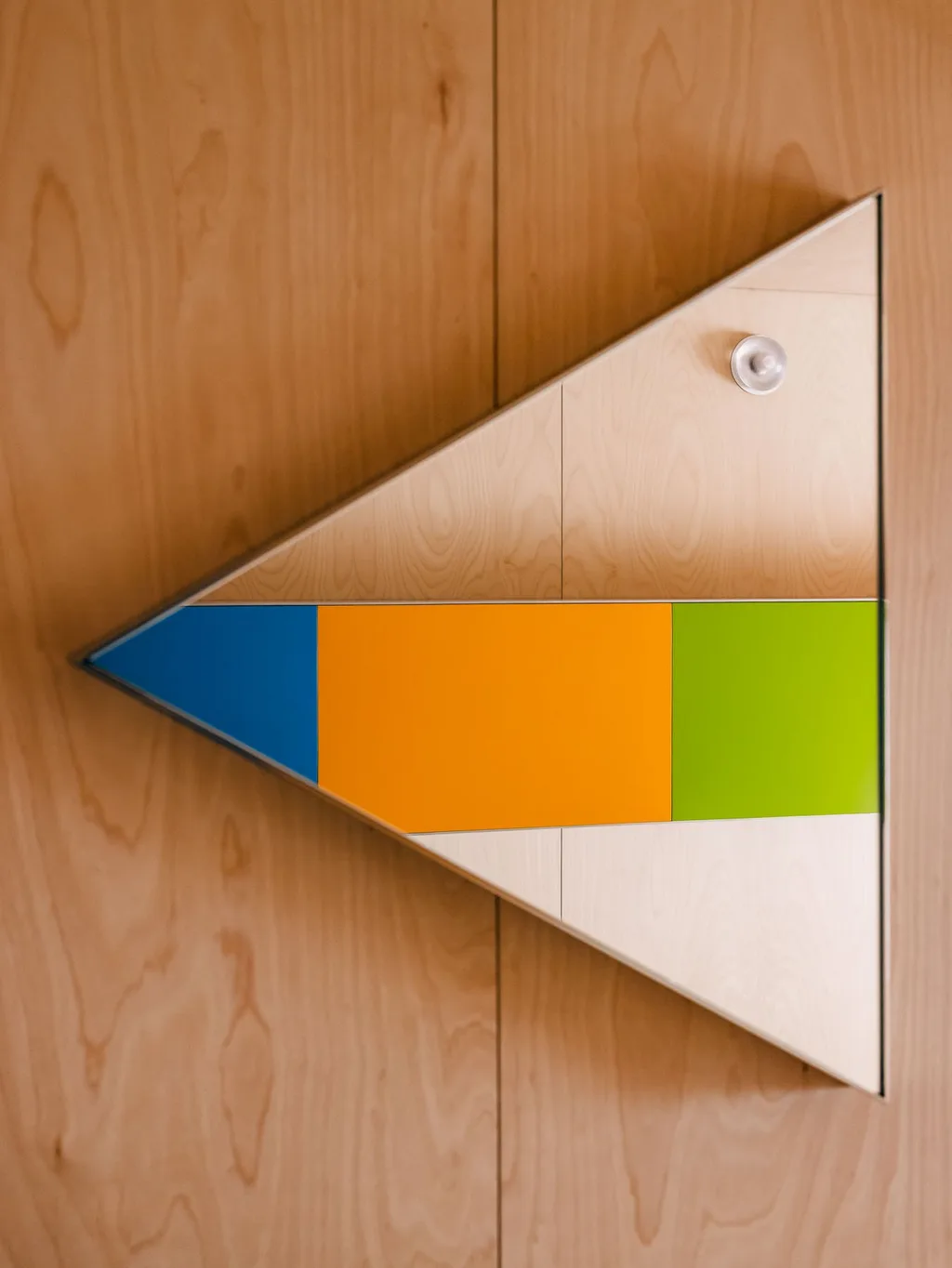 Triangular mirror reflecting bright coloured panels in Laurent Buttazzoni's Paris interior