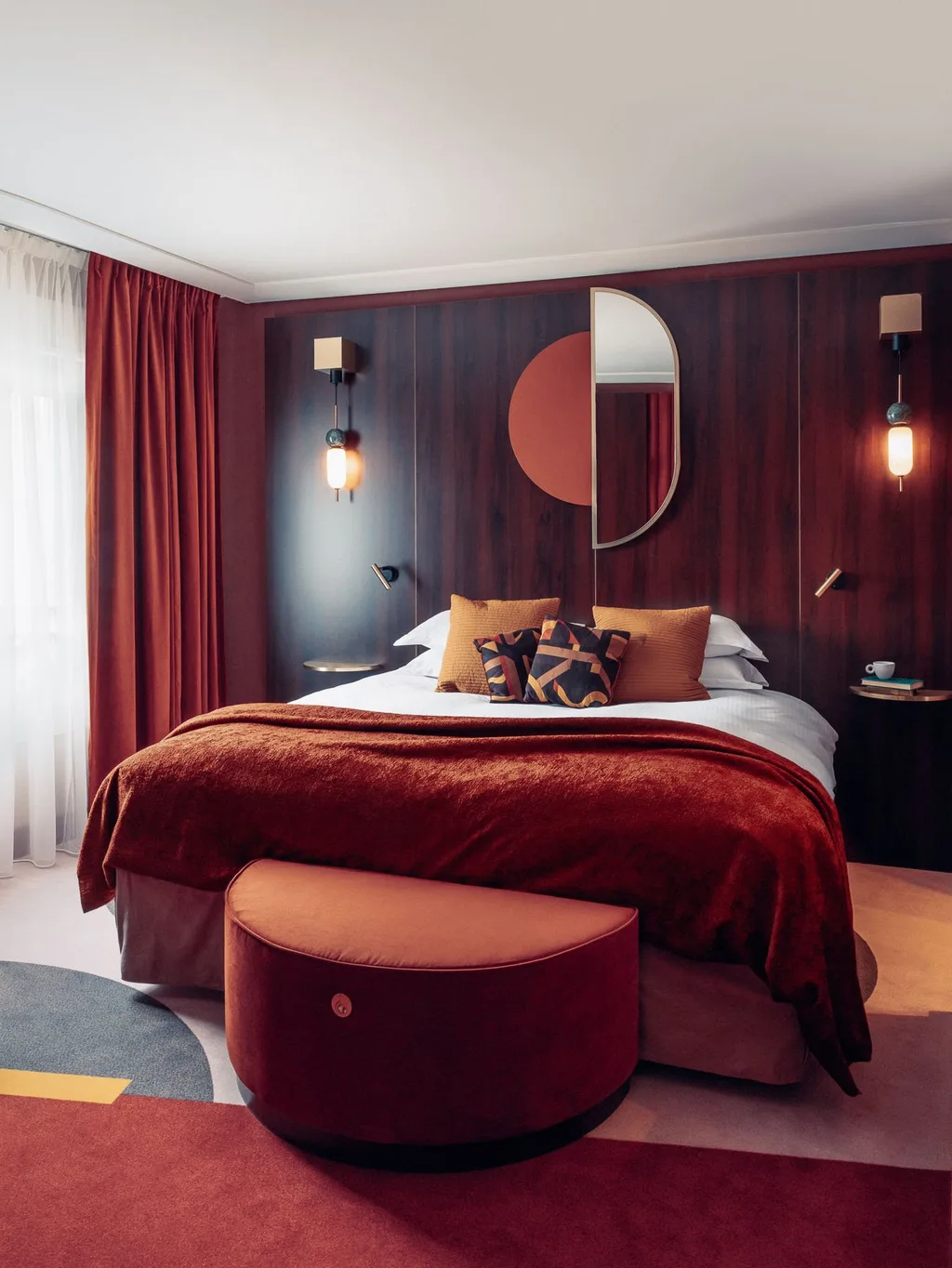 Bed with wood headboard, half-moon mirror and mustard cushions, Nest MGallery Hotel, Paris