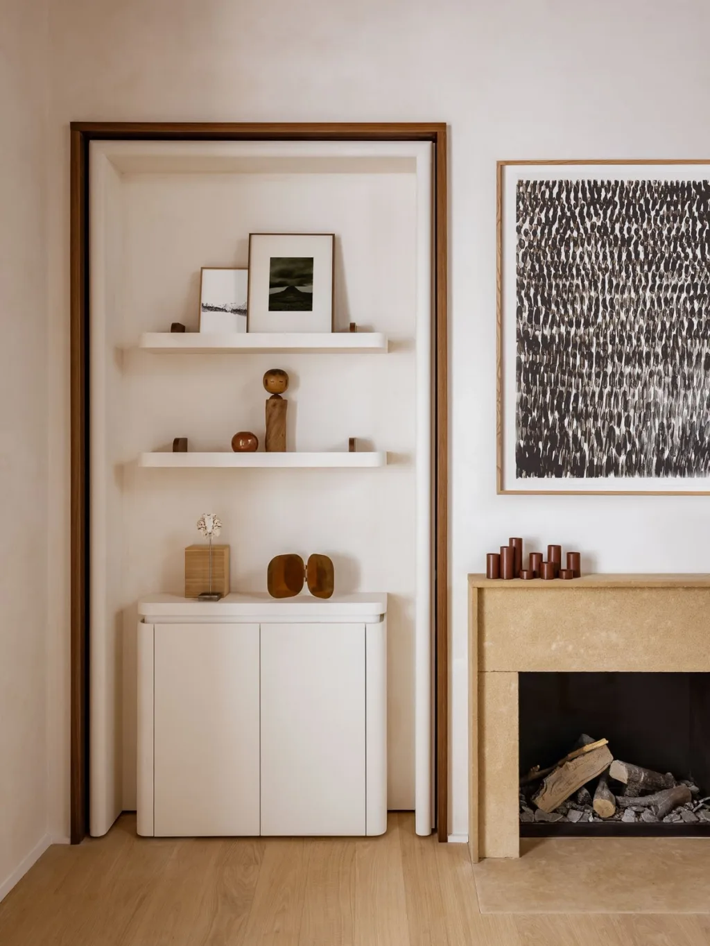 White recessed shelves beside a pale fireplace in Hugues de Blignières' Paris interior