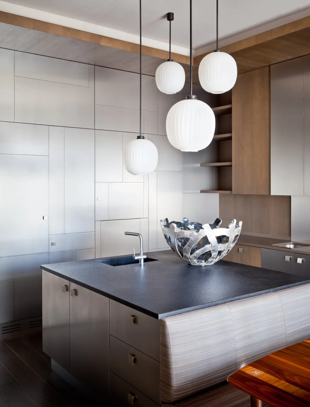 Kitchen island beneath white globe pendants with a sculptural open bowl, Jean Louis Deniot, Paris