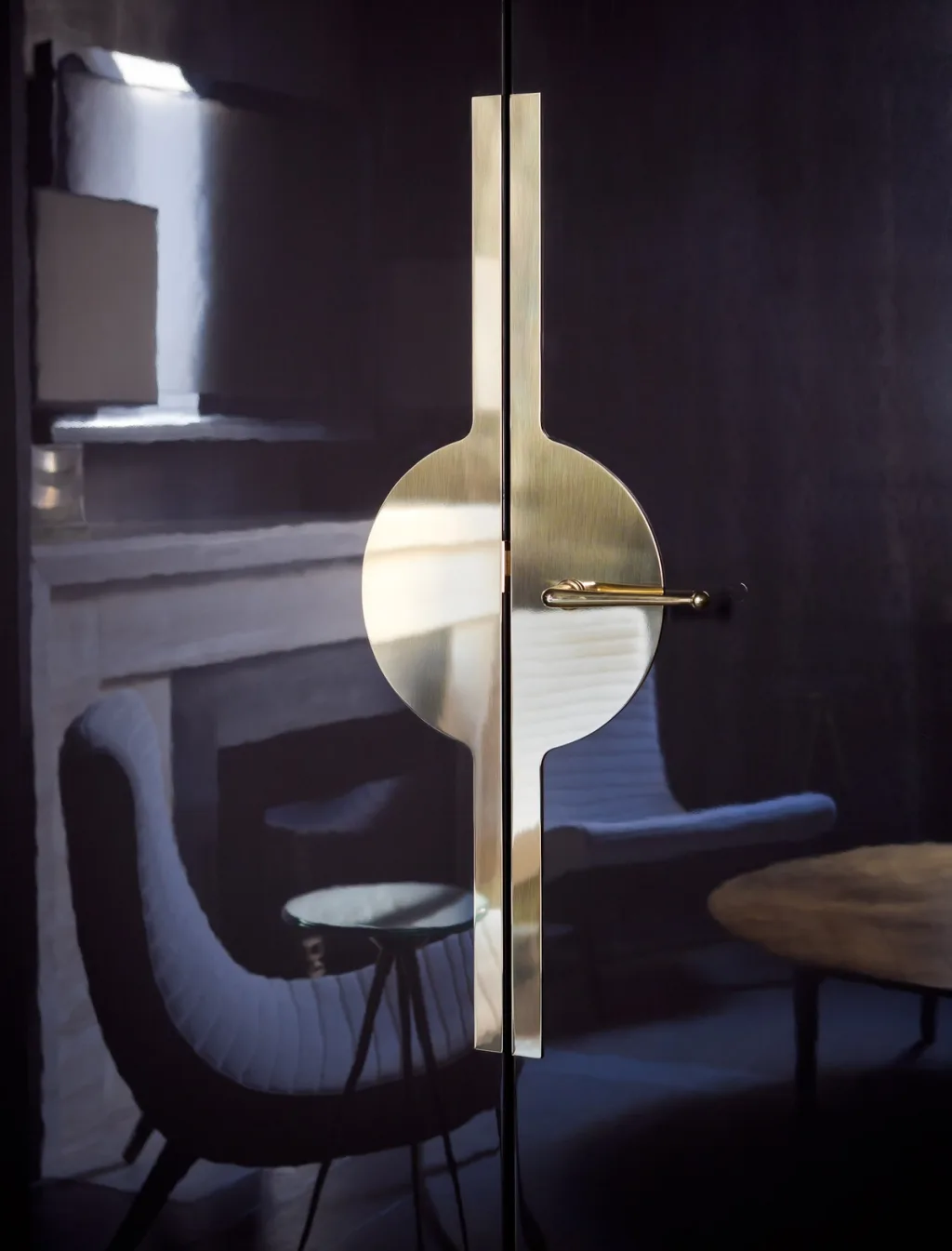 Glossy dark double doors with a circular gold-toned handle plate, Jean Louis Deniot, Paris