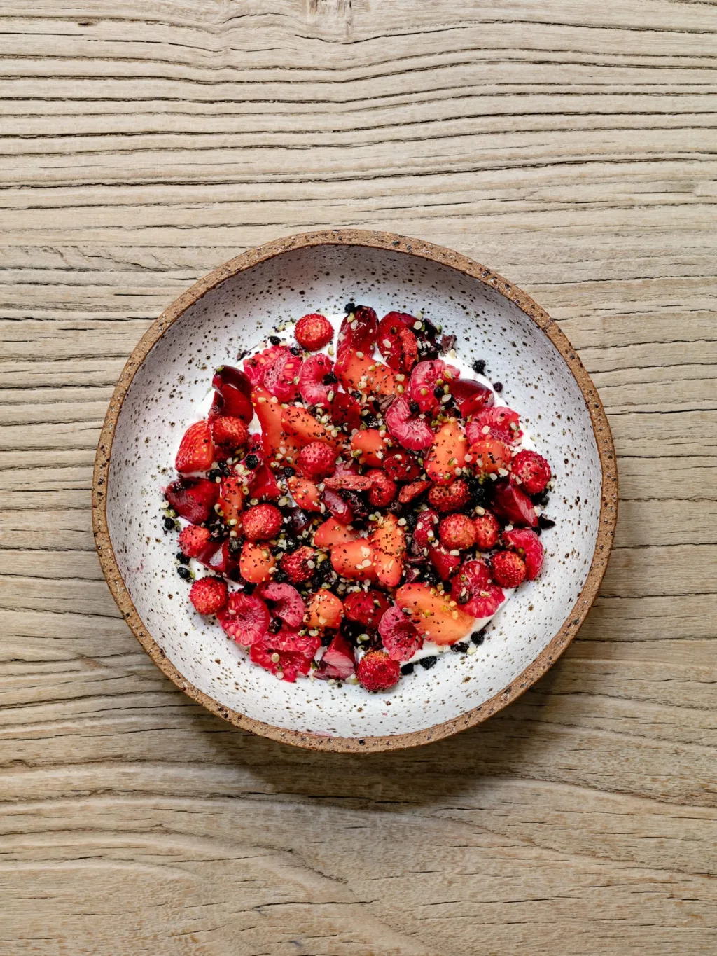 Strawberries, raspberries and dark crumbs on a speckled plate for Cyril Lignac’s Saisons cookbook