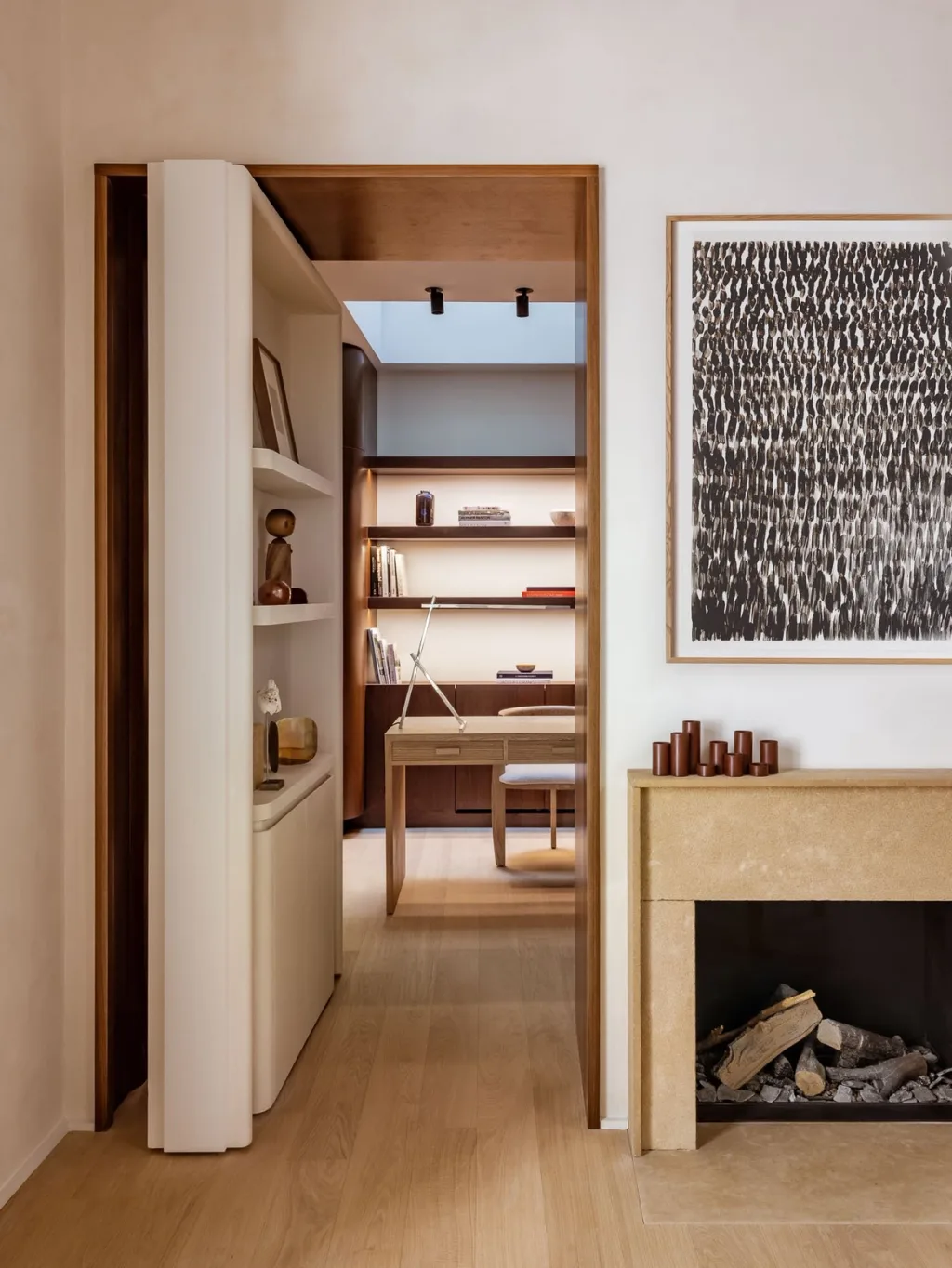 Doorway opening to a compact study beside a fireplace in Hugues de Blignières' Paris interior