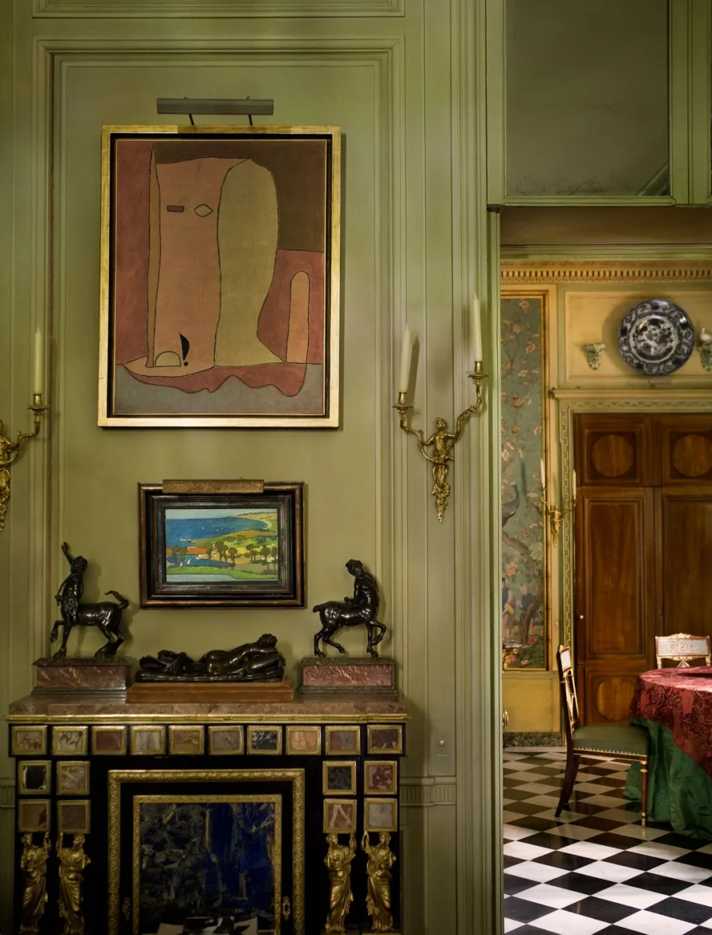 Paintings above a decorative fireplace topped with small sculptures, Pierre Bergé, Paris