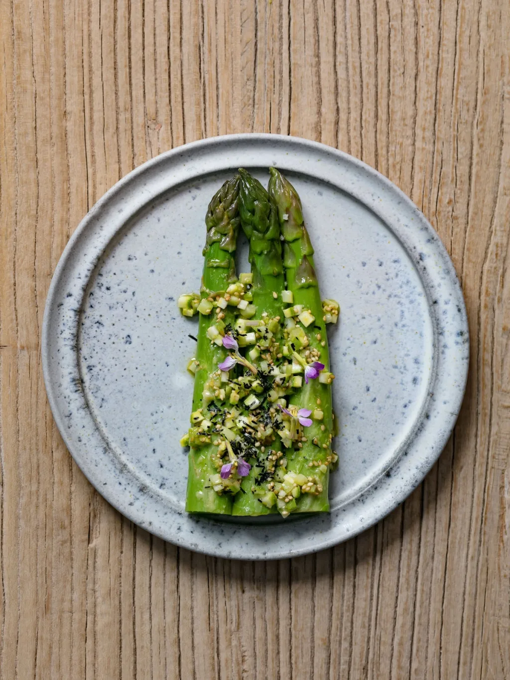 Green asparagus with chopped garnish and tiny flowers for Cyril Lignac’s Saisons cookbook
