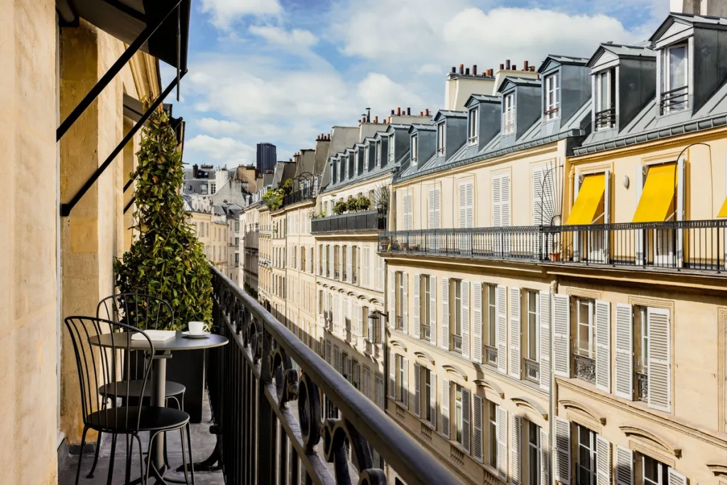 Balcony view over Parisian zinc rooftops and chimneys at Hotel Pavillon St Germain, Paris