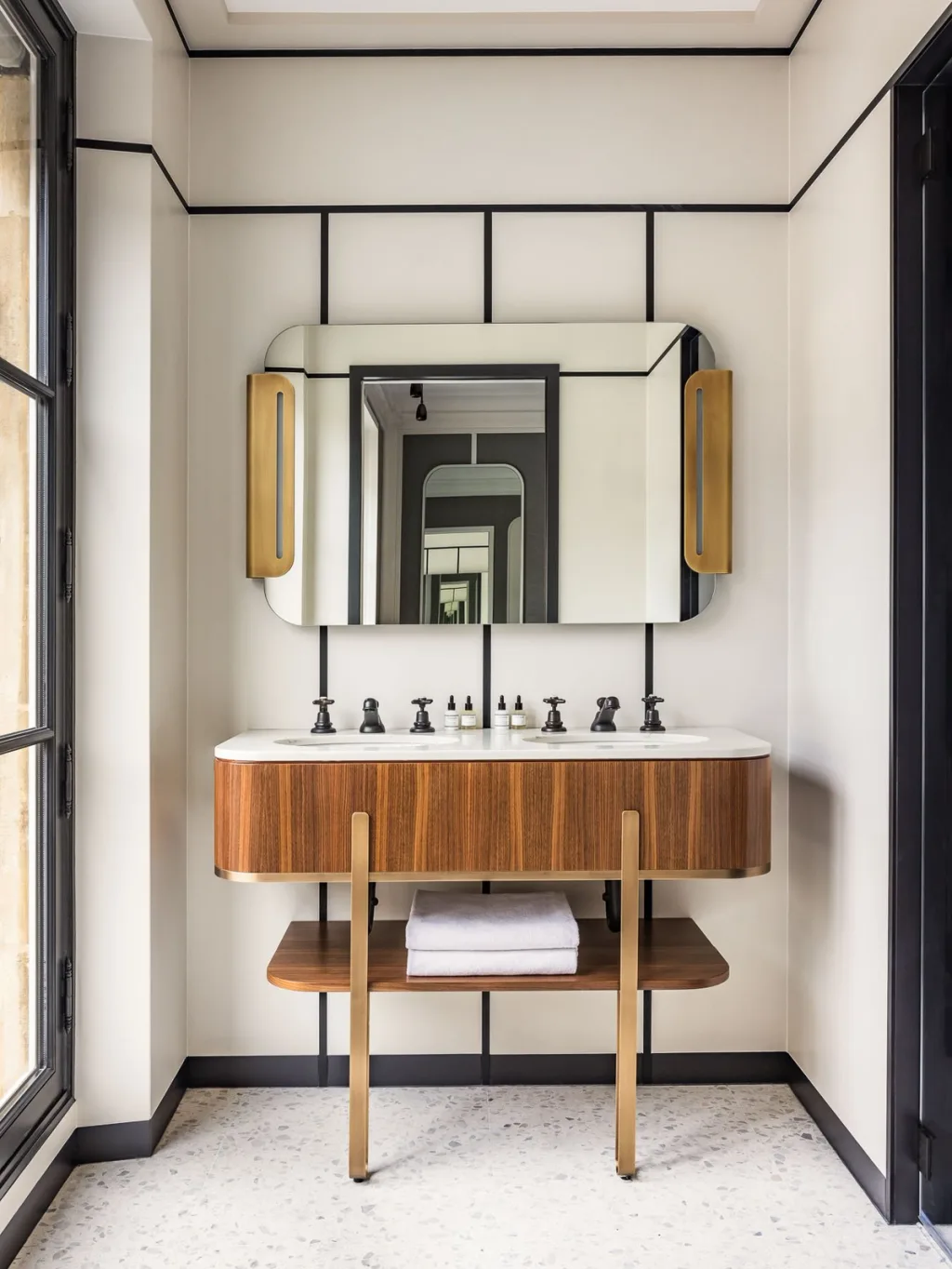 Bathroom with a double wood vanity beneath an arched mirror at Hotel Pavillon St Germain, Paris