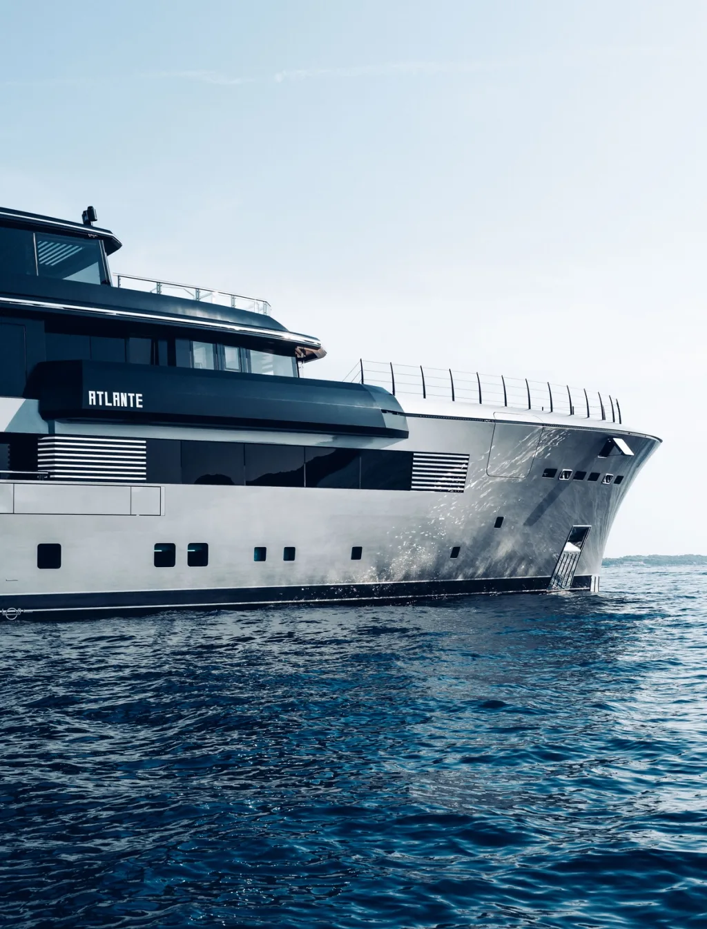 Angular grey bow and dark upper decks of the Atlante yacht viewed from the water