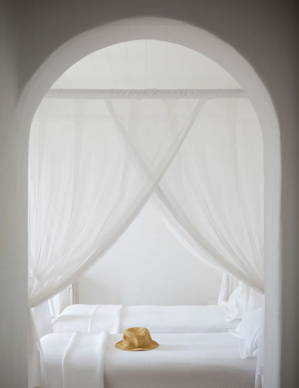 Blue-domed chapel above a stone-terraced pool with a canopied daybed, a hotel in Mykonos