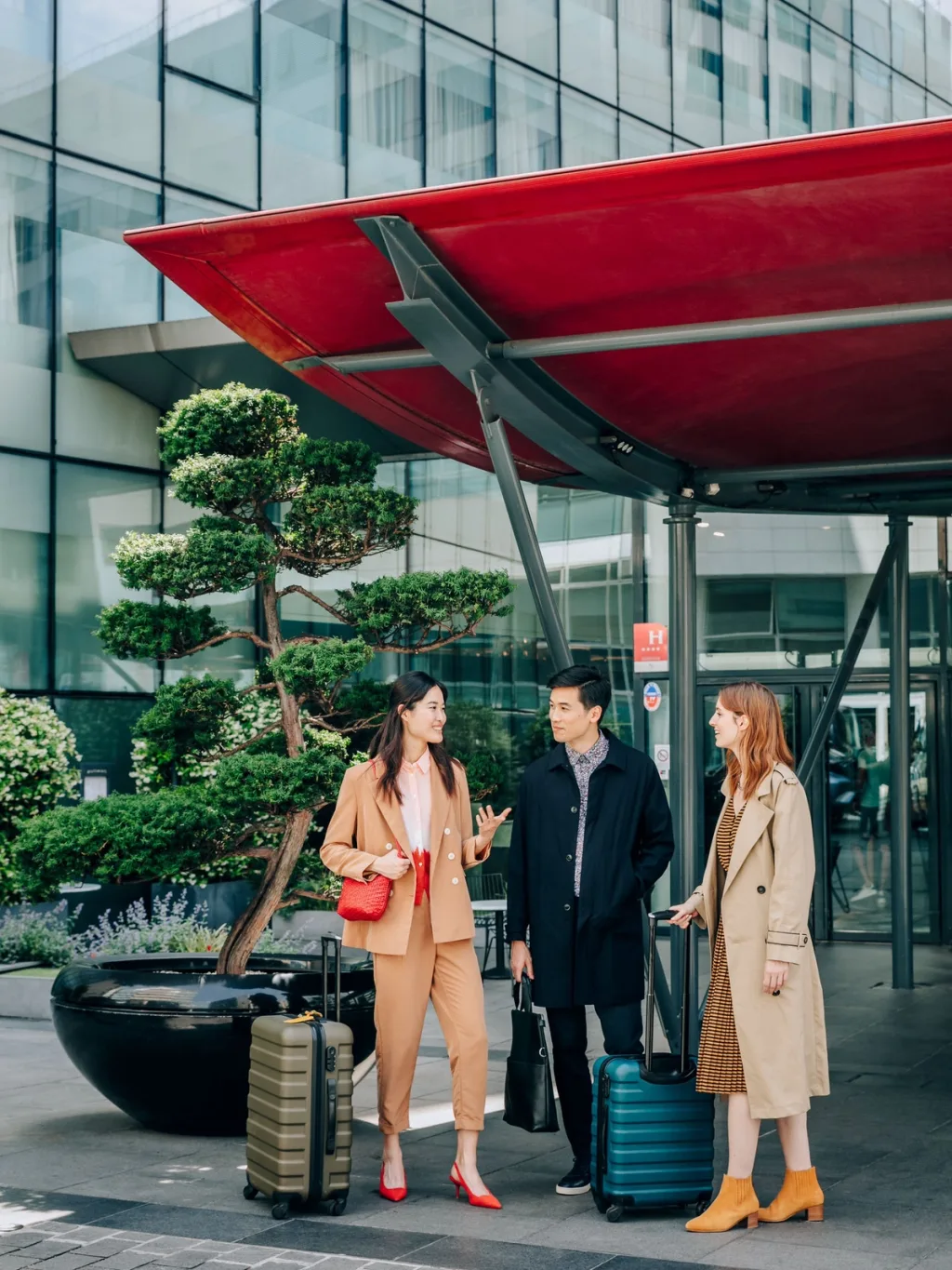 Guests with luggage gathered under the red entrance canopy, Pullman Bercy hotel