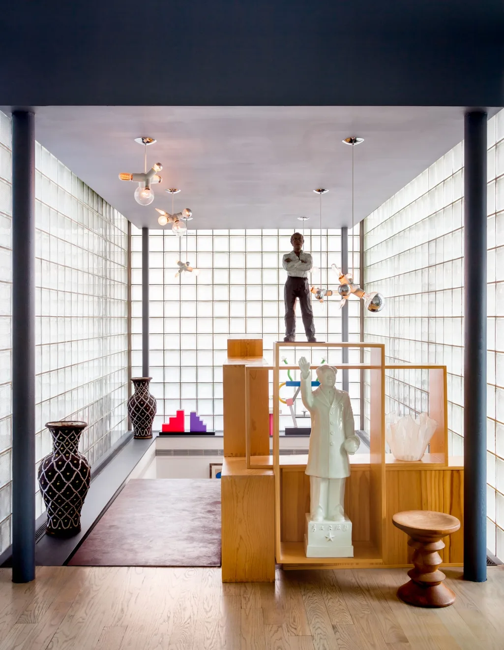 Sculptures on open wooden shelving inside a glass-block interior, Suzanne Slesin, New York