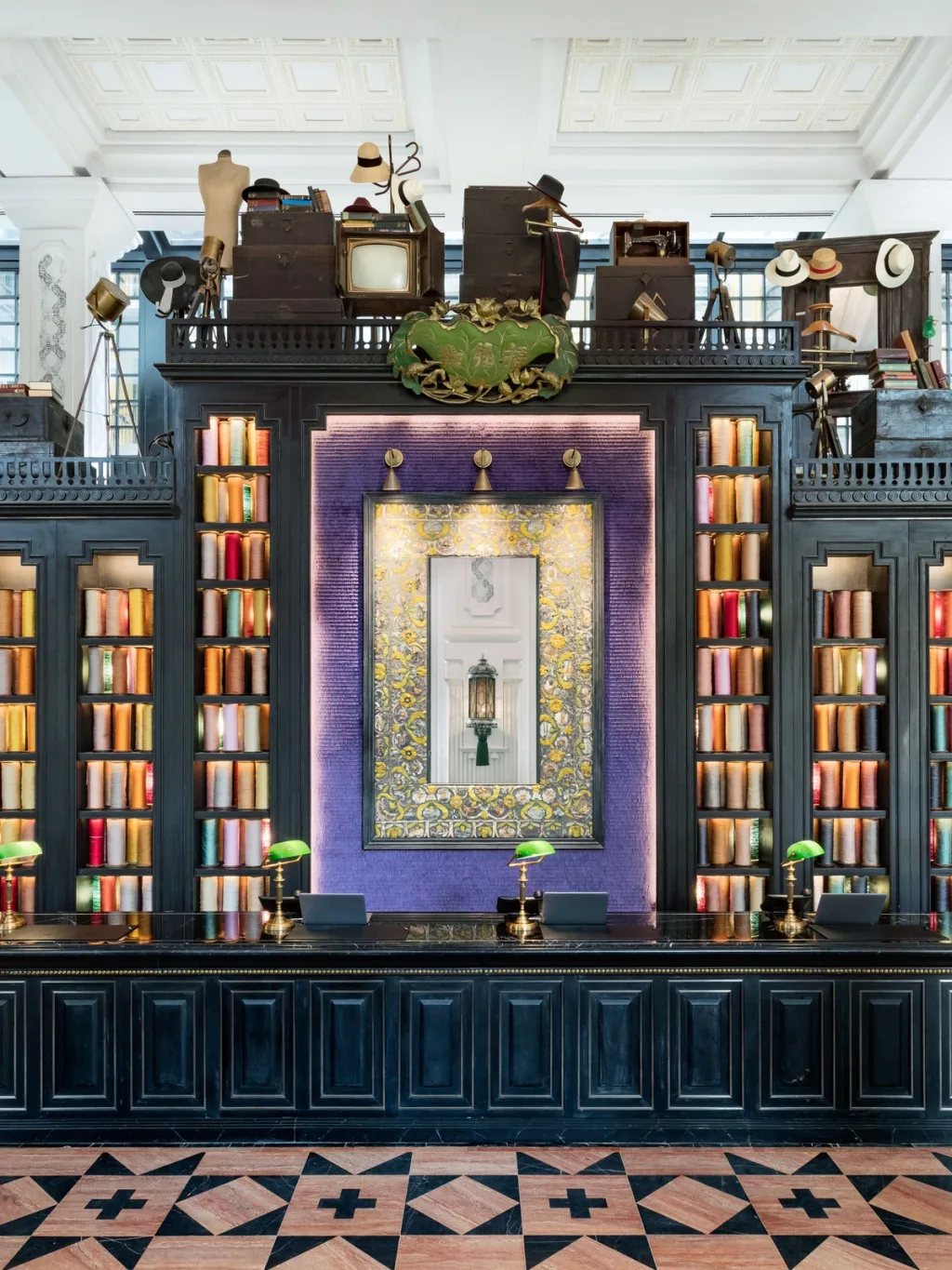 Reception desk with green lamps and shelves of colored thread spools, Hotel de la Coupole MGallery, Sapa, Vietnam