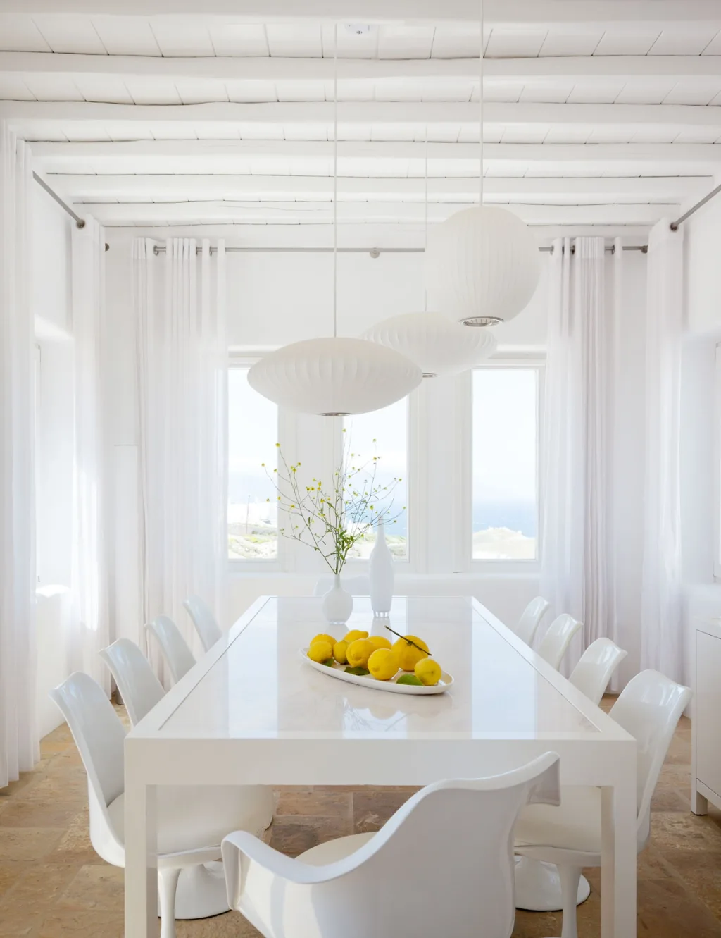 Gallery wall of framed beach illustrations above a white bench, a hotel in Mykonos