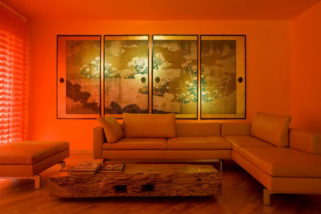 Corner sofa and rough wooden coffee table beneath decorative panels in the Maurizio Galante series, Latina
