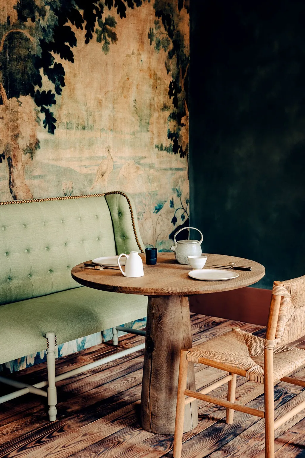 Chinoiserie mural, green banquette and round table set for tea, Manufacture Royale de Lectoure hotel