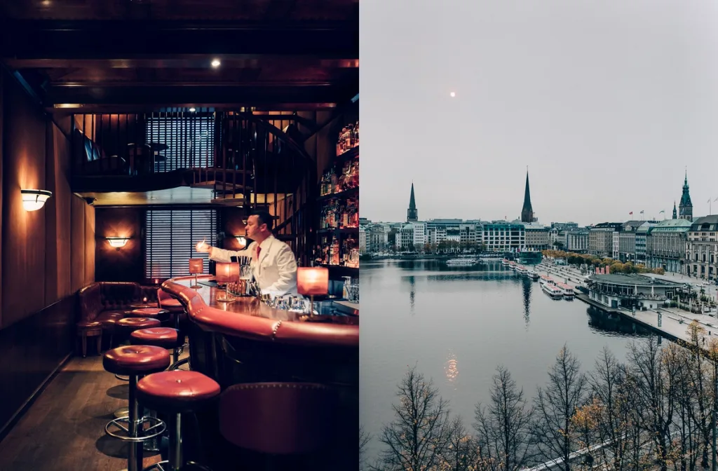 Dimly lit bar with red stools paired with a waterfront city view, Fairmont Hotel, Hamburg