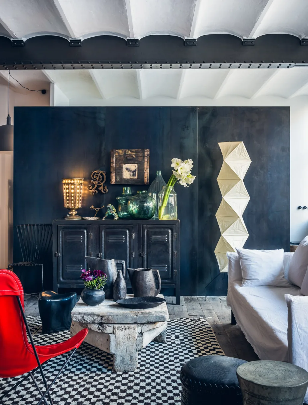 Red chair and pale sofa around a low round table at Daniel Rozensztroch's Paris home