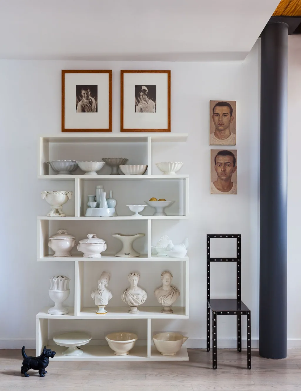 White vessels and busts on zigzag shelves beneath portraits, Suzanne Slesin, New York