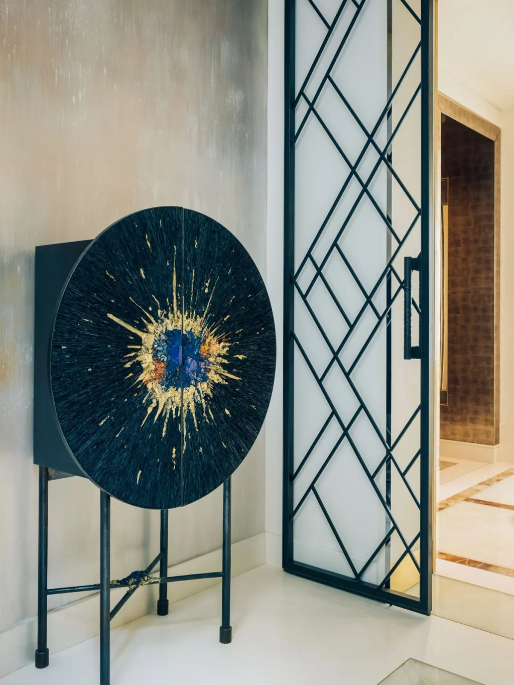 Circular blue artwork beside a geometric glazed door in Stéphanie Coutas' Paris interior
