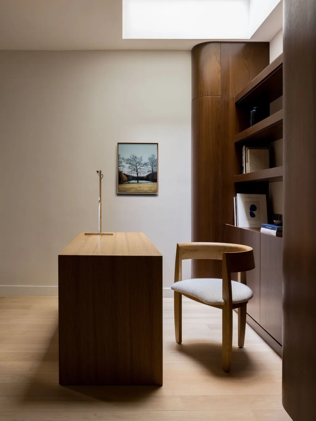 Wooden desk and curved chair beneath a skylight in Hugues de Blignières' Paris interior