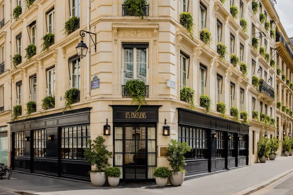 Corner facade with the Les Parisiens sign and ivy-draped balconies at Hotel Pavillon St Germain, Paris