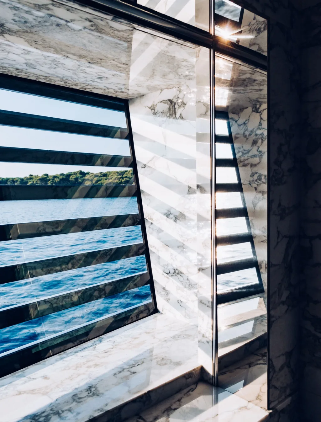 Sea seen through slatted windows and mirrored veined walls aboard the Atlante yacht
